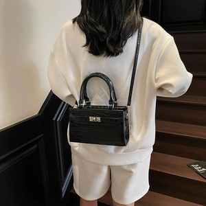 Minimalist black crocodile pattern handbag with silver rotary lock and shoulder strap