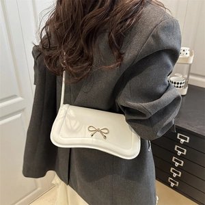 Borsa baguette bianca lucida con fibbia a fiocco dorata e tracolla sottile