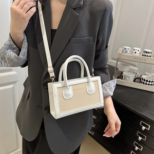Chic beige woven canvas crossbody bag with white faux leather trim shown on model