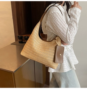 Detail of beige straw hobo bag with brown leather strap and matching mini pouch