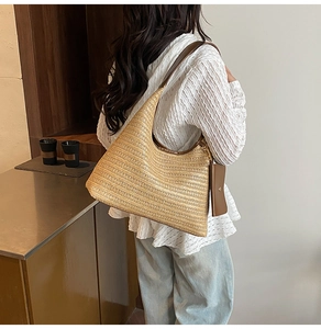Straw tote bag with brown leather strap and mini pouch shown in a casual lifestyle scene