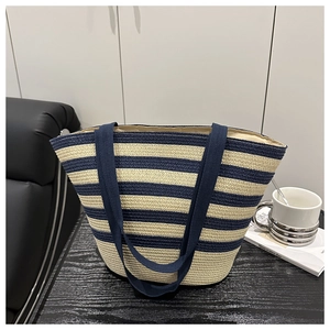 Gros plan du sac cabas tissé à rayures bleu marine et beige avec anses robustes