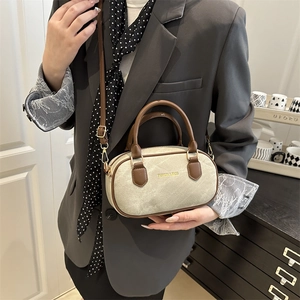 Beige canvas pillow bag with brown leather trim and golden hardware for women