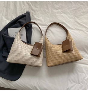 Detail view of woven straw tote bags with leather shoulder straps and matching mini pouches