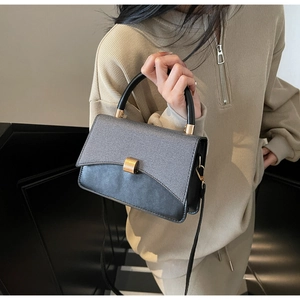 Détail du sac carré stylé avec panneau contrasté et fermoir métallique carré doré