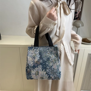 Vintage floral jacquard tote bag with black handles in a stylish minimalist setting