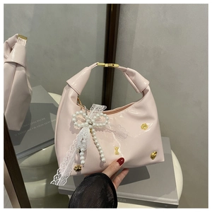 Sac à main rose brillant avec breloques dorées et grand nœud en dentelle perlée