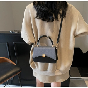 Détail du sac à rabat bicolore avec fermoir doré et bandoulière réglable