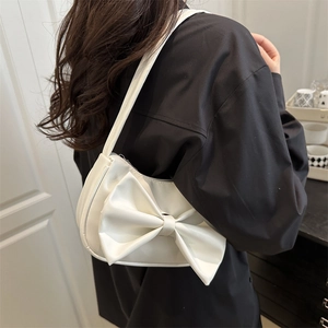 White faux leather crescent shoulder bag with large bow decoration for elegant summer style