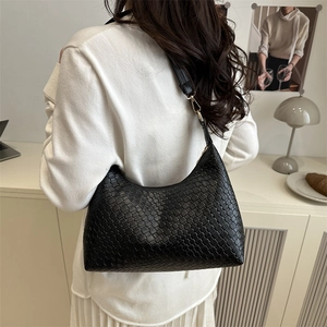 Minimalist black woven PU leather hobo bag with gold hardware shown on model