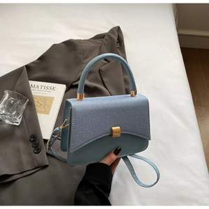 Détail du sac bandoulière en similicuir bleu avec élégante serrure en métal doré