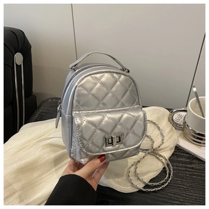 Makro-Detail des silbernen gesteppten Mini-Rucksacks mit Kettengurt und Metallic-Finish