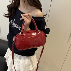 Glossy red Boston handbag with gold lettering and top handles for women