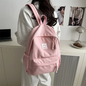Pink Japanese style minimalist backpack for students featuring a smiley face patch