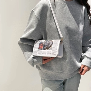 Minimalist white crossbody bag with vintage newspaper print and gold hardware