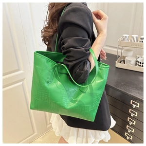 Detail of green tote bag showing mix of smooth leather and embossed crocodile texture