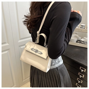 Dettaglio di una borsa squadrata in pelle bianco crema con chiusura in metallo argento