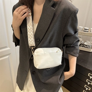 Minimalist white leather crossbody bag with geometric woven strap and gold-tone hardware