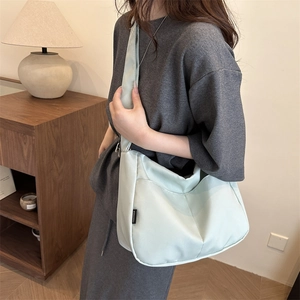 Minimalist mint green nylon half-moon crossbody tote bag with wide strap for daily use