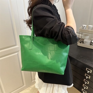 Green faux leather tote bag with mixed animal textures shown in a lifestyle setting