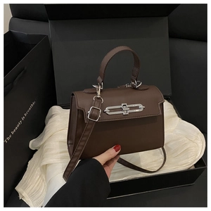 Détail d'un sac à main en cuir marron avec fermoir argenté et coffret cadeau luxe