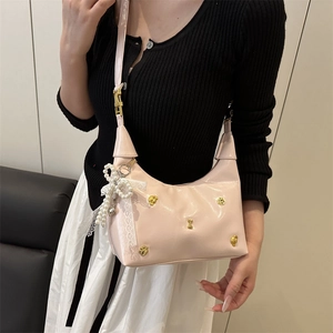Borsa hobo rosa a mezzaluna con borchie dorate e ciondolo fiocco in perle