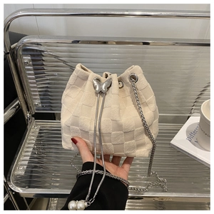 Detail of cream bucket bag with woven checkerboard texture and silver butterfly drawstring