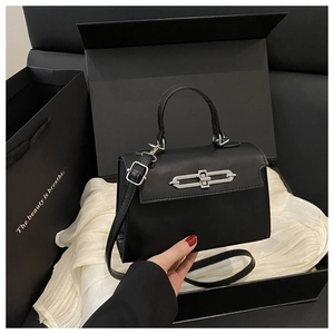 Détail d'un sac à main noir dans une boîte cadeau avec fermoir en métal argenté