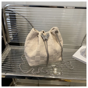 Detailed macro view of cream straw bucket bag with silver butterfly and pearl chain