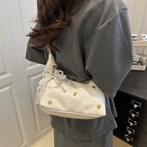 Borsa a tracolla chic in PU crema con fiocco di perle e pizzo indossata da una modella