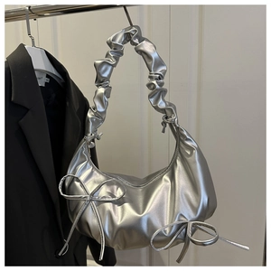 Detail of silver metallic crescent bag with pleated clouds strap and bow accents