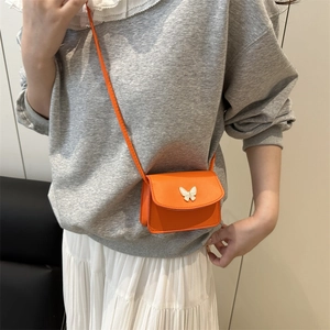 Fashionable orange square crossbody bag with white enamel butterfly buckle on model