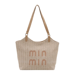 Straw tote bag with brown embroidery and leather straps on white background