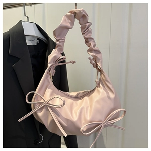 Detail of pink cloud-style shoulder bag featuring soft pleated faux leather and bow knot