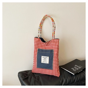 Detail of red and white checkered tote bag with denim pocket and braided rope handle