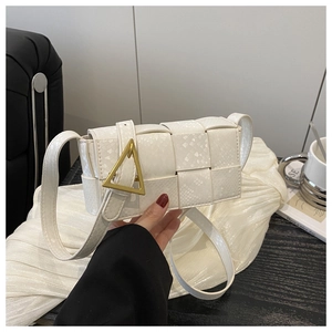 Detail of white woven crossbody bag with gold triangle buckle on premium textured leather