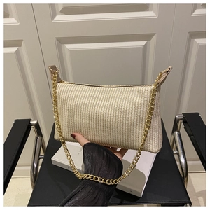 Détail du sac sous le bras tressé beige doté d'une bandoulière à grosse chaîne dorée