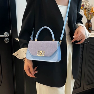 Light blue vintage crossbody bag with gold BB logo and texture shown on shoulder