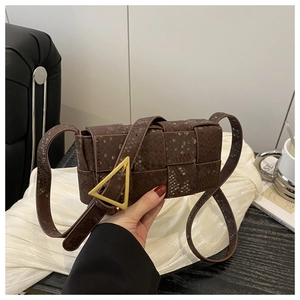 Detail of dark brown snakeskin texture bag with iconic gold triangle buckle closure