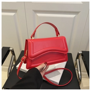 Red leather structured handbag with curved flap detail and elegant gold-tone hardware
