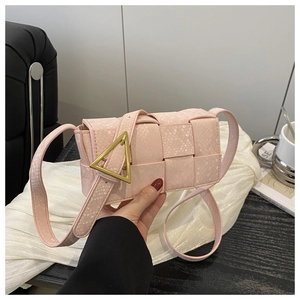 Detail of pink woven crossbody bag featuring a signature gold triangle buckle adjustment