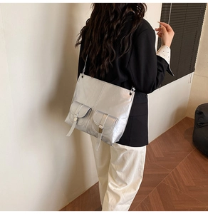 Close-up of metallic silver crossbody bag with mirror finish and multiple pockets