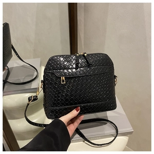 Detail of black woven shell bag featuring gold zippers and premium faux leather texture