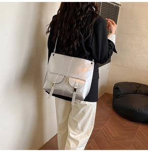 Detail view of silver metallic tote bag with double front buckle pockets for women