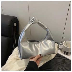 Dettaglio del manico a nodo argento e della finitura metallizzata plissettata della borsa
