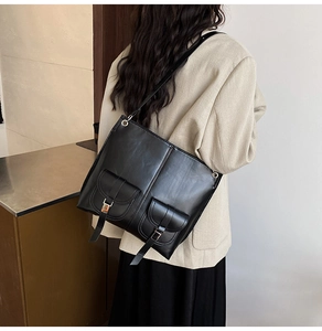 Detail of black PU crossbody bag featuring dual front pockets and fine stitching craftsmanship