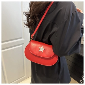 Detail of red saddle bag with rhinestone star buckle worn over a black shirt