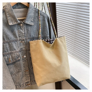 Detail of canvas tote bag with beaded strap and classic fashion embroidery on front