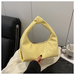 Dettaglio ravvicinato della borsa a mezzaluna giallo vivace con manico a nodo unico