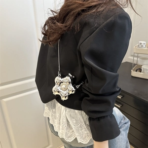 Silberne Blumen-Umhängetasche mit großer Perle und Metallkette am Modell getragen